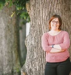 Pastorin Pfeifer lehnt an einem Baum